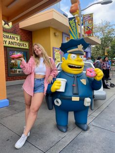 a woman standing next to a cartoon character holding a donut in front of a store