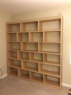 an empty bookcase in the corner of a room with no one on it,