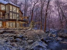 a large house surrounded by trees in the snow