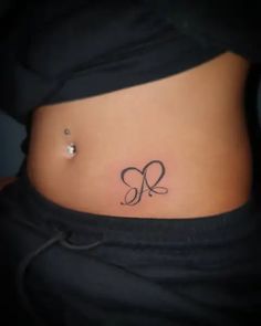 a woman's stomach with a small tattoo on her belly and the letter q in cursive font