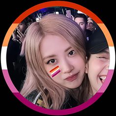 two girls are smiling for the camera with their faces painted orange and pink in front of them