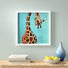 a giraffe standing next to a bowl of lemons and a blue vase