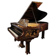 a grand piano with an ornate design on it's body and legs, sitting upright against a white background