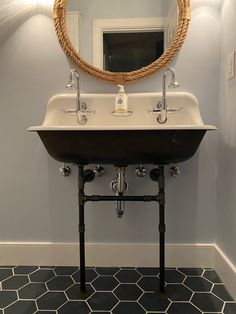 a bathroom sink sitting under a round mirror