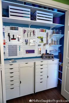 an organized craft room with white cabinets and drawers