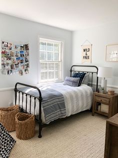 a bed room with a neatly made bed and two baskets on the floor next to it