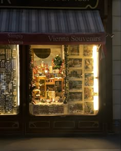 a store front with many items in the window and lit up by lights on either side