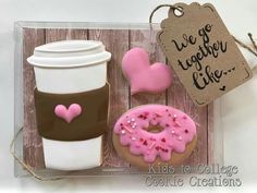 a cup of coffee, donut and cookie in a box with some writing on it