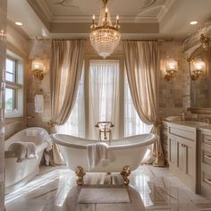 a large bathroom with a claw foot tub and chandelier