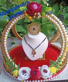 the necklace is on display in front of some flowers