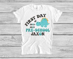 "Super cute First Day Of Preschool shirt, which little boy or girl doesn't love dino's?! These shirts come personalized with year and name. We press our shirts with a professional heat press, use high quality transfer paper and ink and use a small business printer. We use infant bodysuits (one pieces) , sizes 0-3 months, 3-6 months, 6-12 months and 12-18 months. Infant lap tees sizes 6-12 months and 12-18 months. And we use toddler tees (2T, 3T, 4T, 5T) We also have Youth shirts sizes S, M and L First Day Of Preschool Shirt, Dinosaur Tshirt, School T Shirts, First Day Of Preschool, 1st Day Of School, 1st Day, Toddler Tees, Baby Shirts