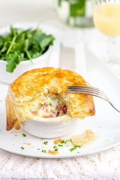 a plate with a piece of quiche on it and a salad in the background