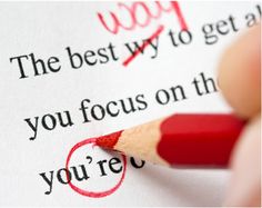 a close up of a person holding a pencil in front of a piece of paper