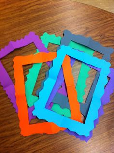 several pieces of colored paper sitting on top of a wooden table