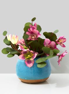 a blue vase filled with pink and yellow flowers