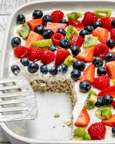 a close up of a cake with fruit on it and a fork in the middle