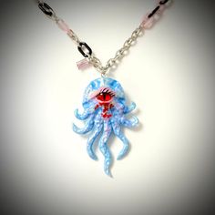 Introducing our Handcrafted Octopus Polymer Clay Necklace, a truly exceptional piece of wearable art. This necklace features a striking octopus pendant with a one-of-a-kind red cat-eye design meticulously handcrafted from polymer clay. The vivid red hues accentuate the octopus's captivating charm, while the delicate light blue color of the octopus itself adds a touch of whimsy. Suspended elegantly from a silver chain, this necklace offers both charm and versatility. Whether you're celebrating the enchantment of Halloween, the romance of Valentine's Day, the milestone of an anniversary, or the joy of a birthday, this necklace is a perfect choice. The octopus, known for its intelligence and mystery, adds a touch of intrigue to your style. This necklace is more than just jewelry; it's a conve Blue Octopus, Octopus Pendant, Octopus Design, Polymer Clay Necklace, Red Cat, Clay Necklace, Necklace Unique, Design Light, Eye Design