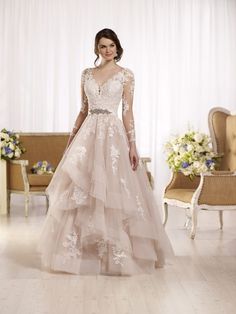 a woman in a wedding dress standing next to a chair with flowers on the floor