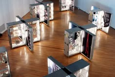 a group of silver boxes sitting on top of a wooden floor next to each other