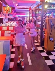 two girls in pink dresses are walking through a diner