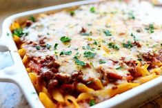 a casserole dish with meat, cheese and sauce in it on a table