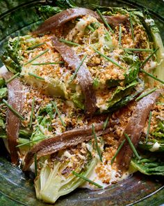 a green plate topped with vegetables covered in toppings