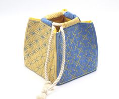 a blue and yellow bag with rope handles