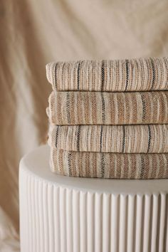 three folded towels sitting on top of a white pedestal