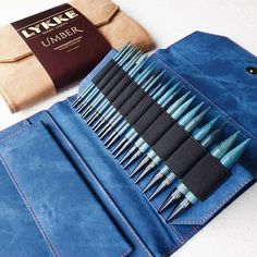 a blue case with brushes in it next to a wallet