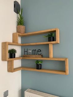 three wooden shelves with plants on them and the word home spelled in cursive letters