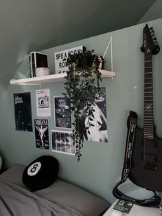 a guitar is hanging on the wall next to a bed in a room with green walls