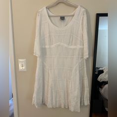 a white top hanging on a wall next to a mirror