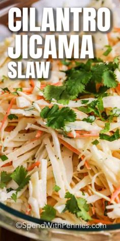 a glass bowl filled with shredded carrots and cilantro jicama slaw