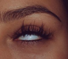 a woman's eye with long lashes and blue eyeshadow, close up