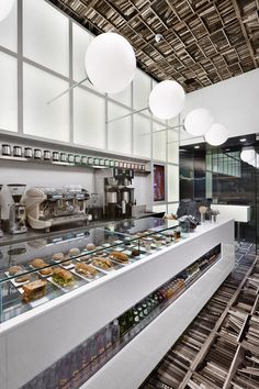 an empty restaurant with lots of food on the counter and lights hanging from the ceiling