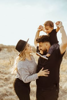 a man, woman and child are standing in the middle of an open field together