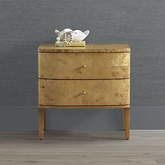 an old chest of drawers with a white vase on top