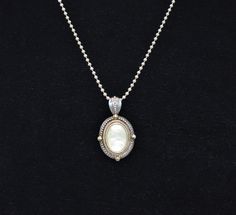 This is a very nice mother of pearl pendant with sterling and 14k vermeil accent frame. The pendant is 1 inch wide and 1 3/4 in height including the bail. The chain is 24 inches long. The pendant is marked 925 with a makers mark of GV. The chain is marked sterling on the clasp. This is in very good estate condition. It will arrive in the black pouch in the last photo. Free shipping. White Mother Of Pearl Necklace With Pearl Pendant, Silver Pearl Pendant Jewelry In Mother Of Pearl, Silver Mother Of Pearl Pendant Pearl Necklace, Polished Mother Of Pearl Pendant Jewelry, Silver-toned Mother Of Pearl Necklace, Black Pouch, Mother Of Pearl Pendant, Swirl Earrings, Mother Of Pearl Necklace