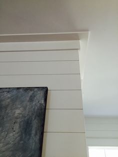 a black and white painting hanging on the wall next to a window in a room