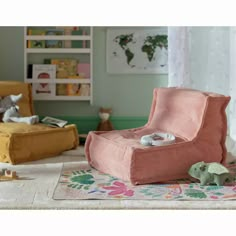 a pink chair sitting on top of a rug next to a stuffed animal toy in a living room