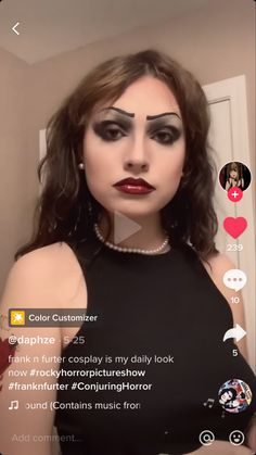 a woman with black makeup is looking at the camera