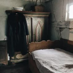 an old bedroom with a bed, dresser and window