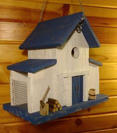 a bird house hanging on the side of a wooden wall