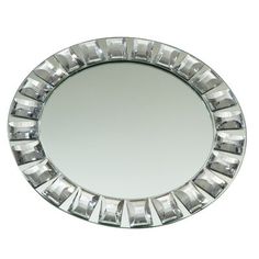 a round mirror that is on top of a white wall and has silver trim around the edges