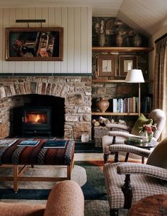 a living room filled with furniture and a fire place in the middle of a fireplace