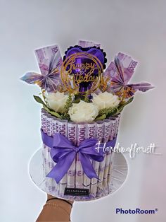 a purple and white birthday cake decorated with flowers