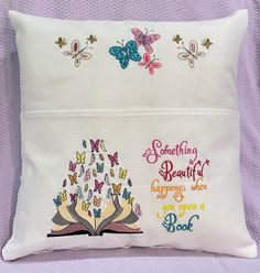 a pillow with two books and butterflies on it, one is embroidered onto the back