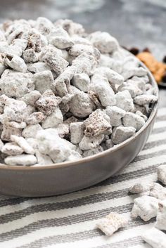 a metal bowl filled with white and brown dog food on top of a striped table cloth