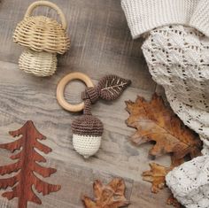 knitted acorns and wooden rings on a table with autumn leaves around them