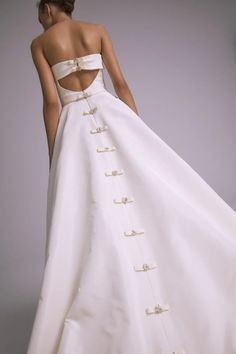 a woman in a white wedding dress with buttons on it